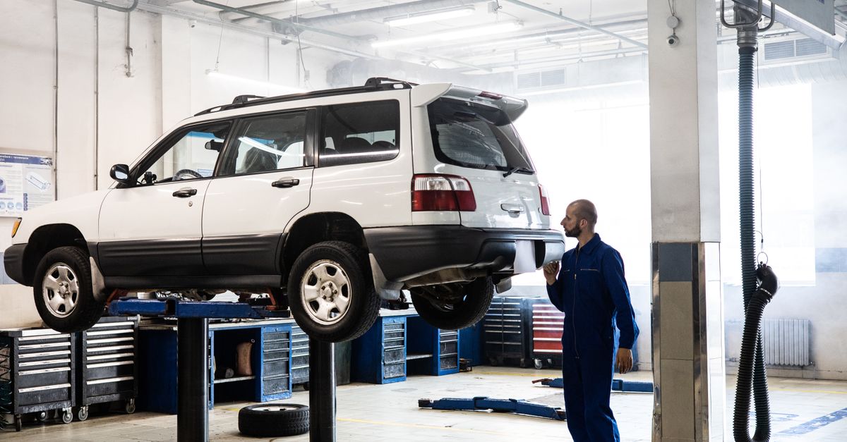 Taller mecánico con una pickup elevada para revisión de mantenimiento
